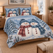 Christmas Snowman Couple Winter Quilt Set on a bed, angled view showing the quilt design and two coordinating pillow shams
