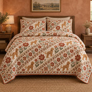 Diagonal bands of small goldendoodles, terracotta folk flowers and leafy motifs create a lively printed stripe on a quilt set with two matching shams, front view.