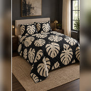 Black and Cream Monstera Quilt Set, angled monstera leaf bedroom view