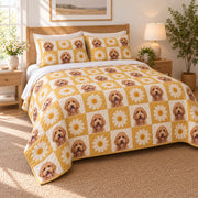 Alternating golden daisy blocks and small goldendoodle portraits create a bright printed checkerboard on cream on a quilt set with two matching shams, angled view.