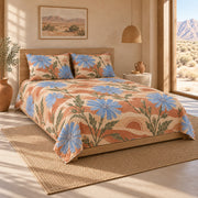 AI mockup of Chicory Blossom Quilt Set, pulled-back front-left view of blue chicory flowers on sunwashed terracotta bedding