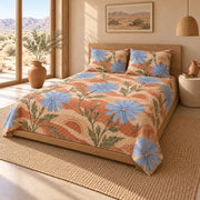 AI mockup of Chicory Blossom Quilt Set, pulled-back front-right view of blue chicory flowers on sunwashed terracotta bedding