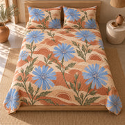 AI mockup of Chicory Blossom Quilt Set, centered high overhead view of blue chicory flowers on sunwashed terracotta bedding