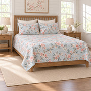 Coral cherry blossom quilt set on a long oak bed, left angle view
