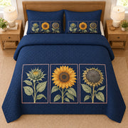 AI mockup, high overhead bedroom view of a sunflower quilt with three sunflower botanical panels on navy and two matching printed pillow covers.