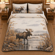 AI mockup, high overhead bedroom view of a moose quilt with moose wading beside autumn willow branches and two matching printed pillow covers.