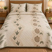 AI mockup, front bedroom view of a dinosaur quilt with two decorative dinosaur footprint trails in sage and tan framed by ferns and two matching printed pillow covers.