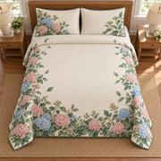AI mockup, high overhead bedroom view of a hydrangea quilt with pink and blue hydrangea hedge border and two matching printed pillow covers.