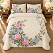 AI mockup, high overhead bedroom view of a hydrangea quilt with open pink and blue hydrangea wreath and two matching printed pillow covers.
