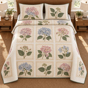 AI mockup, high overhead bedroom view of a hydrangea quilt with hydrangea botanical specimens in printed paper-style frames and two matching printed pillow covers.