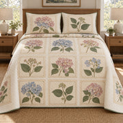 AI mockup, front bedroom view of a hydrangea quilt with hydrangea botanical specimens in printed paper-style frames and two matching printed pillow covers.