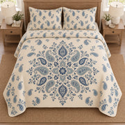 AI mockup, high overhead bedroom view of a paisley quilt with central blue paisley mandala and two matching printed pillow shams.