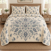 AI mockup, front bedroom view of a paisley quilt with central blue paisley mandala and two matching printed pillow shams.