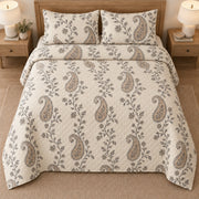 AI mockup, high overhead bedroom view of a paisley quilt with trailing floral vines and neutral paisleys and two matching printed pillow shams.