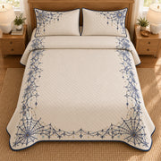 AI mockup, high overhead bedroom view of a Halloween quilt with navy spiderweb frame and golden decorative accents and two matching printed pillow covers.
