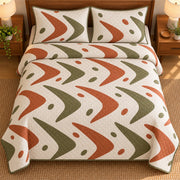 AI mockup, high overhead bedroom view of a mid century modern quilt with terracotta and olive boomerang shapes with scattered oval accents on cream and two matching printed pillow covers.
