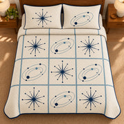 AI mockup, high overhead bedroom view of a mid century modern quilt with navy starbursts and blue orbital shapes in a cream grid and two matching printed pillow covers.