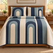 AI mockup, front bedroom view of a mid century modern quilt with navy and muted blue nested arches arranged in vertical cream columns and two matching printed pillow covers.