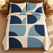 AI mockup, high overhead bedroom view of a mid century modern quilt with navy and muted blue offset circular forms in six cream panels and two matching printed pillow covers.