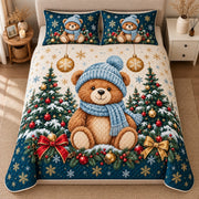 AI mockup, high centered overhead view of a teddy bear wearing a blue knit hat and scarf among Christmas trees, golden ornaments and navy accents, quilt and two matching printed pillowcases in a neutral bedroom.