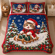 AI mockup, high centered overhead view of a kitten in a Santa hat riding a wooden sled between snowy Christmas trees, with a navy sky and red border, quilt and two matching printed pillowcases in a neutral bedroom.