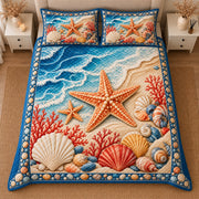 AI mockup, high centered overhead view of large orange starfish, layered seashells and coral on sand beside blue ocean waves, quilt and two matching printed pillowcases in a neutral bedroom.
