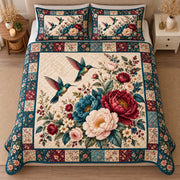 AI mockup, high centered overhead view of hummingbirds flying among burgundy ivory and teal flowers with a floral patchwork border, quilt and two matching printed pillowcases in a neutral bedroom.