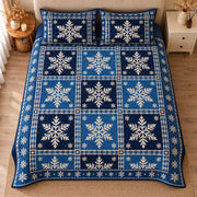 AI mockup, high centered overhead view of large ivory snowflakes in varied navy and blue patchwork squares, quilt and two matching printed pillowcases in a neutral bedroom.