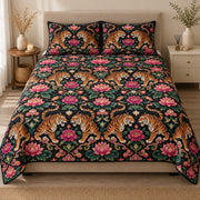AI mockup, front view of mirrored orange tigers surrounded by pink flowers and green botanical scrolls on black, quilt and two matching printed pillowcases in a neutral bedroom.