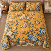 AI mockup, high centered overhead view of blue birds, flowering branches and blue and cream peonies on golden yellow, quilt and two matching printed pillowcases in a neutral bedroom.