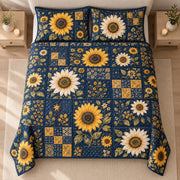 AI mockup, high centered overhead view of large yellow and ivory sunflowers among navy and gold floral patchwork squares, quilt and two matching printed pillowcases in a neutral bedroom.